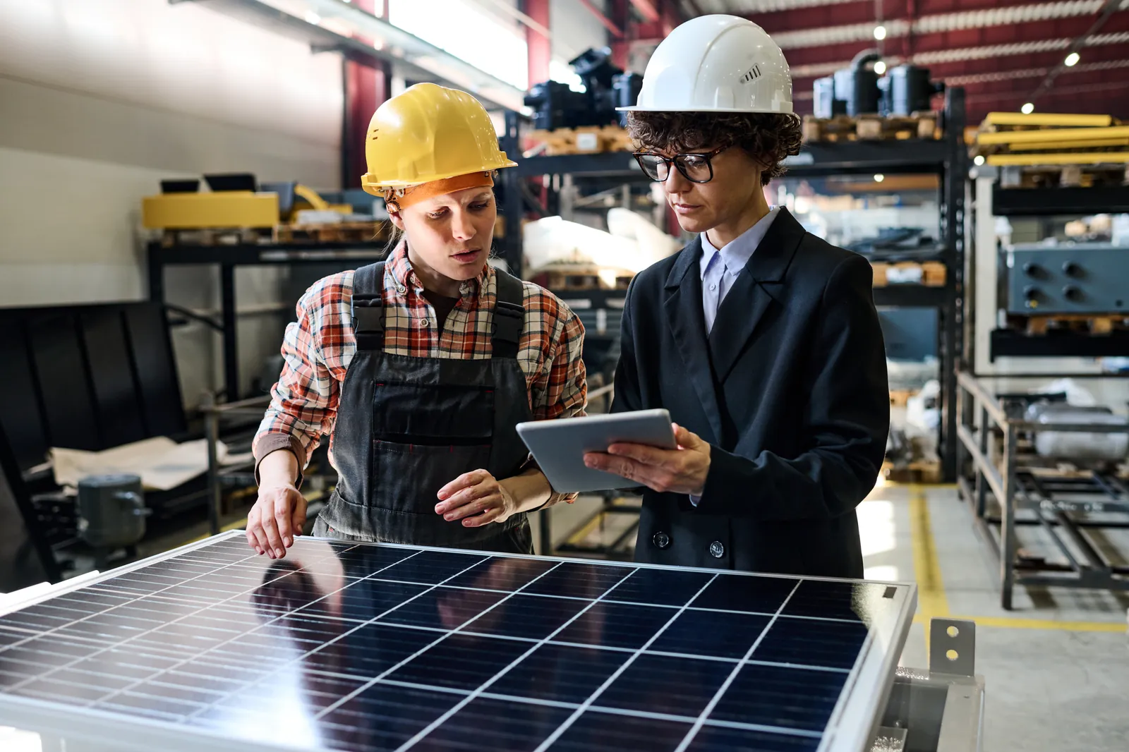 Engineers reviewing production data for solar panels on the factory floor